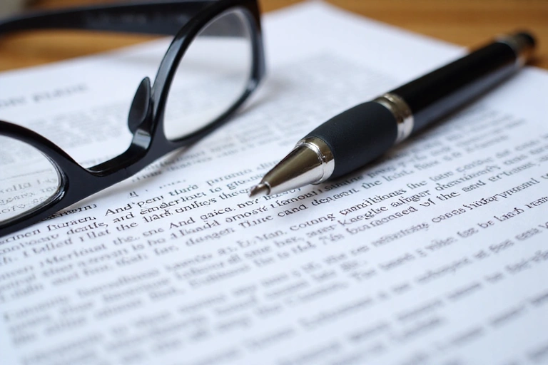 Legal document with a pen and glasses, symbolizing terms and conditions.